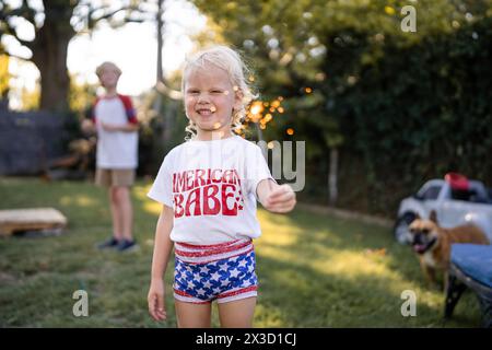 Kleines Mädchen Lächelt Groß, Während Es Mit Wunderkerzen Spielt Stockfoto