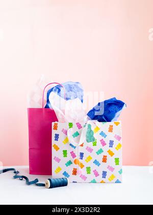 Lebendige Geschenktüten und Taschentücher auf rosa Stockfoto