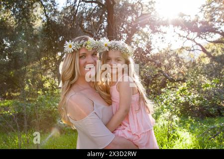 Sonnenküsst und fröhlich, Mutter und Tochter teilen eine liebevolle Umarmung Stockfoto