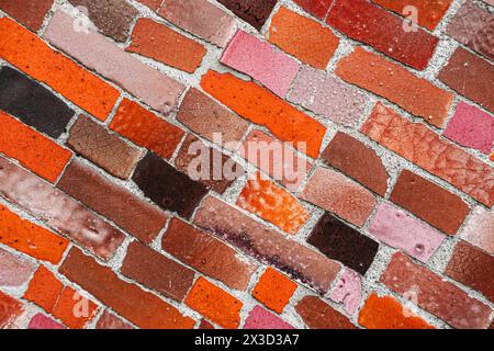 Wandmosaik aus strukturiertem rotem und rosafarbenem Ziegelmosaik aus nächster Nähe Stockfoto