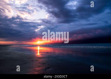 Stürmischer Sonnenaufgang über dem Meeresstrand. Stockfoto