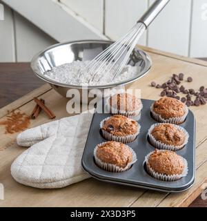 Frische Muffins und Backzutaten auf einer rustikalen Küchentheke Stockfoto