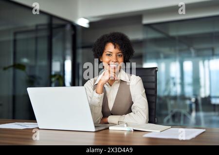 Junge glückliche professionelle afrikanische Geschäftsfrau am Schreibtisch, Porträt. Stockfoto