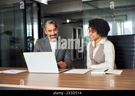 Zufriedene professionelle Geschäftsleute, die im Büro mit Laptop arbeiten. Stockfoto