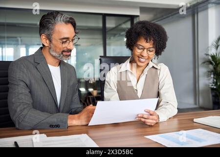 Zwei glückliche Geschäftsleute, die sich mit Dokumenten treffen. Stockfoto