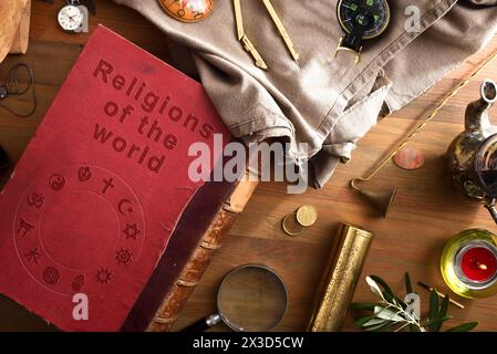 Allgemeine Ansicht des alten und verschlechterten Buches der Religionen der Welt mit eingravierten Buchstaben und religiösen Symbolen verschiedener Religionen auf dem Umschlag Stockfoto