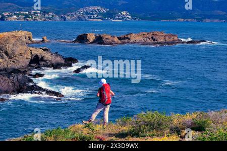 Wanderer steht an der felsigen Küste von Llanca, Spanien, Katalonia, Costa Blanca Stockfoto