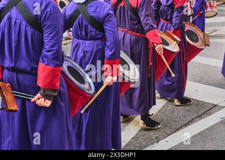 Tarragona, Spanien - 26. April 2024: Gruppe von Menschen in traditioneller Kleidung, Trommeln und Clubs, Teilnahme an einer kulturellen oder religiösen Veranstaltung, cr Stockfoto