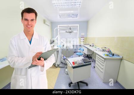 Lächelnder Arzt im weißen Labormantel vor dem Hintergrund der zahnärztlichen Praxis Stockfoto