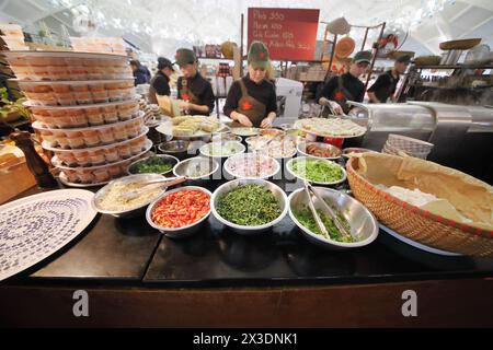 MOSKAU - 19. JAN 2017: Schüsseln mit Gemüse und Gemüse auf der Theke vor Vietnamesen in Kappen mit Sternen in einem Café auf dem Danilovsky-Markt in Stockfoto