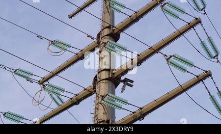 Säule und Stromleitungen gegen einen bewölkten Himmel Stockfoto