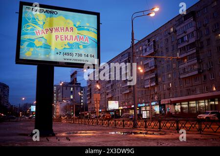 MOSKAU, RUSSLAND - 28. Februar 2017: Straßenverkehr auf der Autobahn in der Nähe von Reklametafeln mit Aufschrift Außenwerbung am Winterabend. Stockfoto