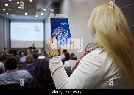 MOSKAU, RUSSLAND - 25. APR 2017: Junge blonde Frau steht mit Heft in der Hand im Auditorium voller Menschen im Novotel Moscow City Hotel d Stockfoto