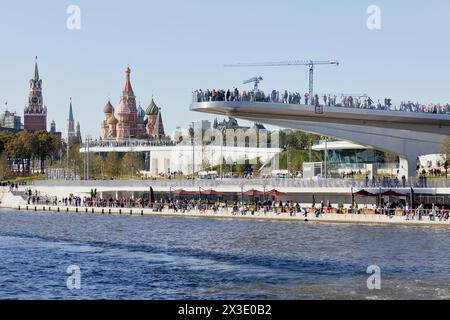 MOSKAU, RUSSLAND - 24. SEP 2017: Moskworetskaya-Damm, schwimmende Brücke des Sarjadje-Parks über dem Fluss Moskva, Spasskaya-Turm und Basilius-Kathedrale Stockfoto