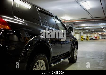 MOSKAU, RUSSLAND - 12. November 2017: Schwarzer Mitsubishi Pajero Sportwagen in Tiefgarage, Ansicht von rechts. Stockfoto