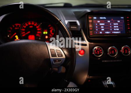 Lenkrad und leuchtendes Armaturenbrett, Fokus auf das Rad. Stockfoto