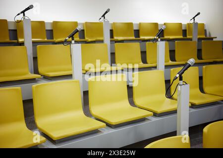 Gelbe Stühle und Mikrofone im Auditorium. Stockfoto