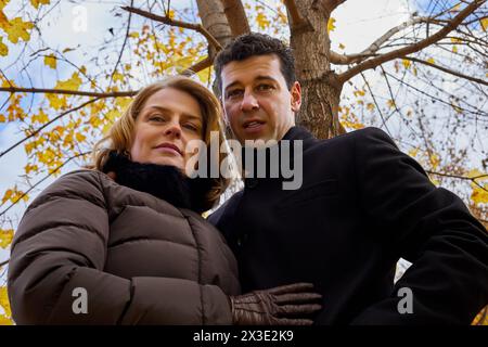 Porträt von Mann und Frau, die am Herbsttag unter Ahornbaum stehen, Tiefwinkelansicht. Stockfoto