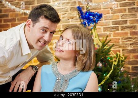 Porträt eines lächelnden Paares im Zimmer, das zu weihnachten dekoriert ist. Stockfoto