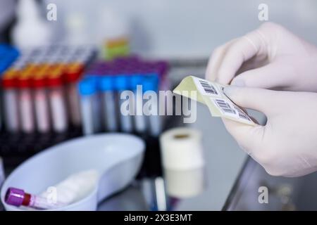 Laborassistent hält Aufkleber mit Barcodes, flacher freiheitsgrad. Stockfoto