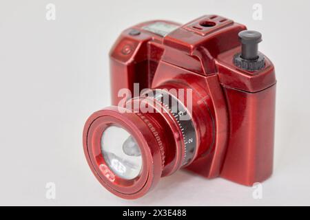 Rote Taschenlampe in Form einer Kamera auf weißem Hintergrund. Stockfoto
