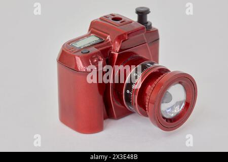 Taschenlampe in Form einer roten Fotokamera auf weißem Hintergrund. Stockfoto