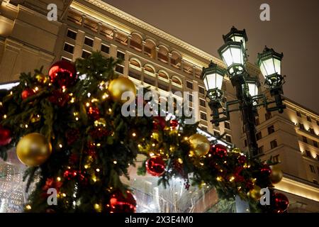 Weihnachtsdekoration und Laterne vor Gebäude und Himmel in der Winternacht. Stockfoto