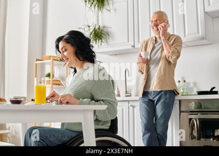 Eine behinderte Frau im Rollstuhl und ihr Mann zusammen in ihrer Küche. Stockfoto