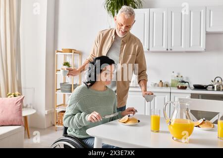 Eine behinderte Frau im Rollstuhl und ihr Mann kochen zusammen in ihrer Küche zu Hause. Stockfoto