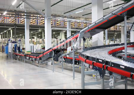 Große leere moderne Werkstatt mit Förderern zum Sortieren von Waren Stockfoto