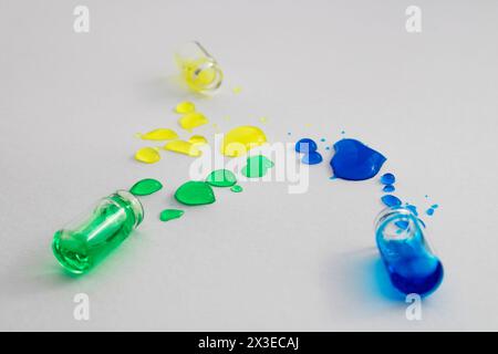 Flaschen mit verschütteter grüner, blauer und gelber Tinte Stockfoto
