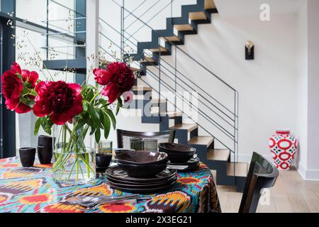 Schöne rote Blumen auf dem Esstisch in der stilvollen Brüsseler Wohnung, Belgien, Europa Stockfoto