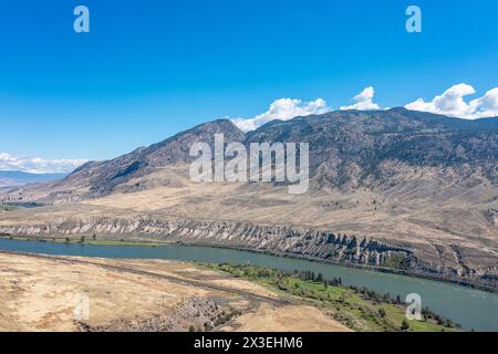 Horizontale Aussichtsoberfläche des Flusses zwischen den Bergen. Luftbild von Drohne. Blauer Himmel Hintergrund Stockfoto