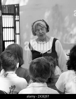 Eine Frau in Kolonialkleidung unterrichtet eine Gruppe von Kindern über die Geschichte von Old Saint Augustine, Florida, USA. Stockfoto