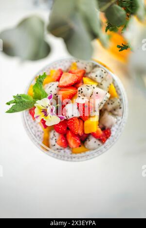 Chia Samenpudding mit Erdbeeren, Mango, Drachenfrucht im Glas auf Marmortisch. Gesundes vegetarisches Frühstück oder Snack. Stockfoto