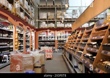 Viele Weinregale im großen modernen Supermarkt, Boxen mit Flaschen Stockfoto