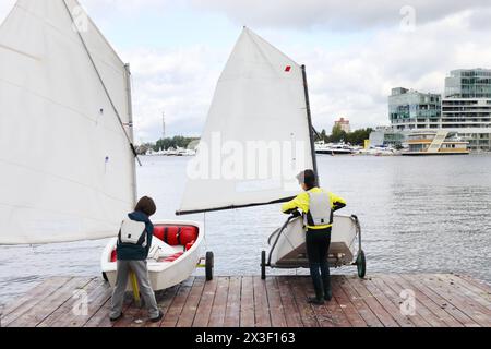 MOSKAU - 16. September 2017: Zwei Jungen setzten kleine Yachten über Wasser in den See im Yachtclub auf der Voykowskaja Stockfoto