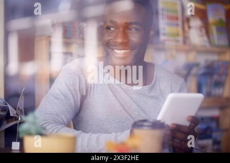 Bibliothek, Student und Schwarzer mit Lächeln, Tablet und Digital für Forschung, Studium und Web für Projekte. Verbindung, Universität und Typ im Geschäft Stockfoto