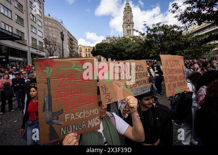 Porto, Portugal. April 2024. Demonstranten in der Aliados Avenue mit Plakaten zum 50. Jahrestag der Nelkenrevolution. Tausende von Menschen nahmen an den Feierlichkeiten zum 50. Jahrestag des 25. April in Porto Teil. Am 25. April 1974 beendete eine militärische Revolution, die als Nelkenrevolution bekannt war, die Diktatur des Estado Novo und stellte die Demokratie in Portugal wieder her. Seitdem wird dieser Tag als Freiheitstag gefeiert. Quelle: SOPA Images Limited/Alamy Live News Stockfoto