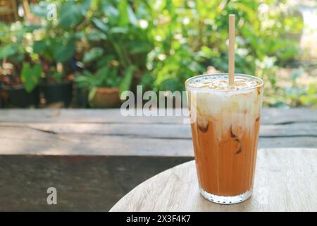 Ein Glas köstlicher thailändischer Eistee auf einem Gartentisch Stockfoto