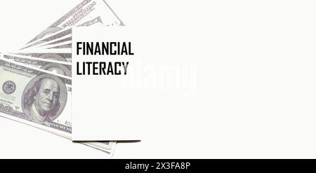 Dollar auf hellem Hintergrund, ein Notizblock mit dem Text FINANZKOMPETENZ. Geschäftskonzept Stockfoto