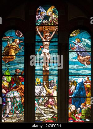 MAILAND, ITALIEN - 6. MÄRZ 2024: Kreuzigung auf dem Buntglas der Kirche Basilica di San Babila von 20. Cent. Stockfoto