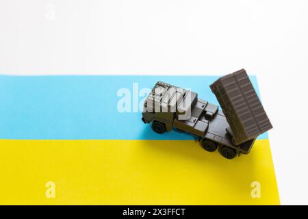 Artillerie-Raketensysteme sind auf den Himmel und Soldaten bei Sonnenuntergang mit ukrainischer Flagge gerichtet. Raketensystem mit mehreren Starts. Stockfoto