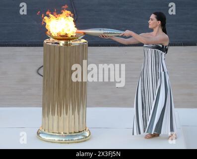 Athen, Griechenland. April 2024. Die Schauspielerin MARY MINA spielt eine alte griechische Hohepriesterin und hält eine Fackel mit der olympischen Flamme während der Übergabemeldung der olympischen Flamme im Panathenaic-Stadion. Die Olympischen Sommerspiele 2024, offiziell die Spiele der XXXIII. Olympiade (Paris 2024), finden vom 26. Juli bis 11. August 2024 in Frankreich statt. (Kreditbild: © Aristidis Vafeiadakis/ZUMA Press Wire) NUR REDAKTIONELLE VERWENDUNG! Nicht für kommerzielle ZWECKE! Quelle: ZUMA Press, Inc./Alamy Live News Stockfoto