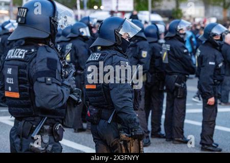 Hamburg, Deutschland. April 2024. Fußball: Bundesliga 2, FC St. Pauli - Hansa Rostock, Spieltag 31, Millerntor Stadium. Polizeibeamte sichern den Abgang der Fans aus dem Stadion nach dem letzten Pfeifen. Quelle: Axel Heimken/dpa/Alamy Live News Stockfoto