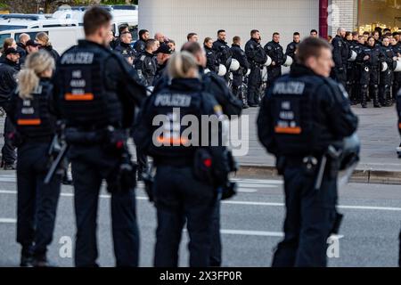 Hamburg, Deutschland. April 2024. Fußball: Bundesliga 2, FC St. Pauli - Hansa Rostock, Spieltag 31, Millerntor Stadium. Polizeibeamte sichern den Abgang der Fans aus dem Stadion nach dem letzten Pfeifen. Quelle: Axel Heimken/dpa/Alamy Live News Stockfoto