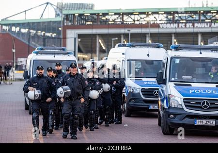 Hamburg, Deutschland. April 2024. Fußball: Bundesliga 2, FC St. Pauli - Hansa Rostock, Spieltag 31, Millerntor Stadium. Polizeibeamte sichern den Abgang der Fans aus dem Stadion nach dem letzten Pfeifen. Quelle: Axel Heimken/dpa/Alamy Live News Stockfoto