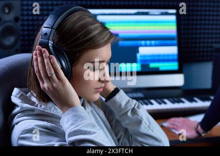 Nachdenkliche Art Director in Kopfhörern, Musik im Tonstudio hören Stockfoto