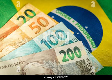 Brasilianisches Geld auf dem Hintergrund der Nationalflagge, Symbole von Brasilien, Wirtschaftskonzept Stockfoto