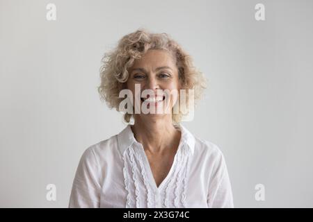 Schöne blonde, lockige, reife Frau posiert im Studio Stockfoto